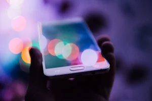 White phone under colored lights to illustrate the photo revolution with photophones, the photographer's equipment nowadays