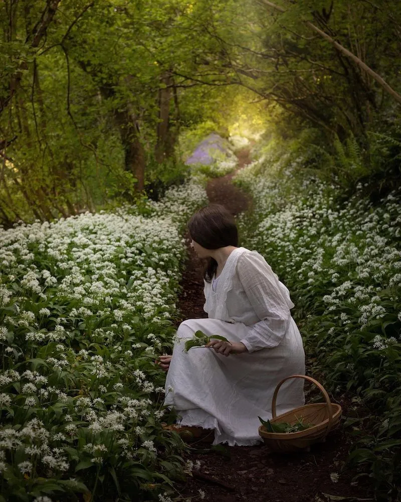 Photography of a woman collecting flowers from a field, taken by Aimee Twigger, food photographer