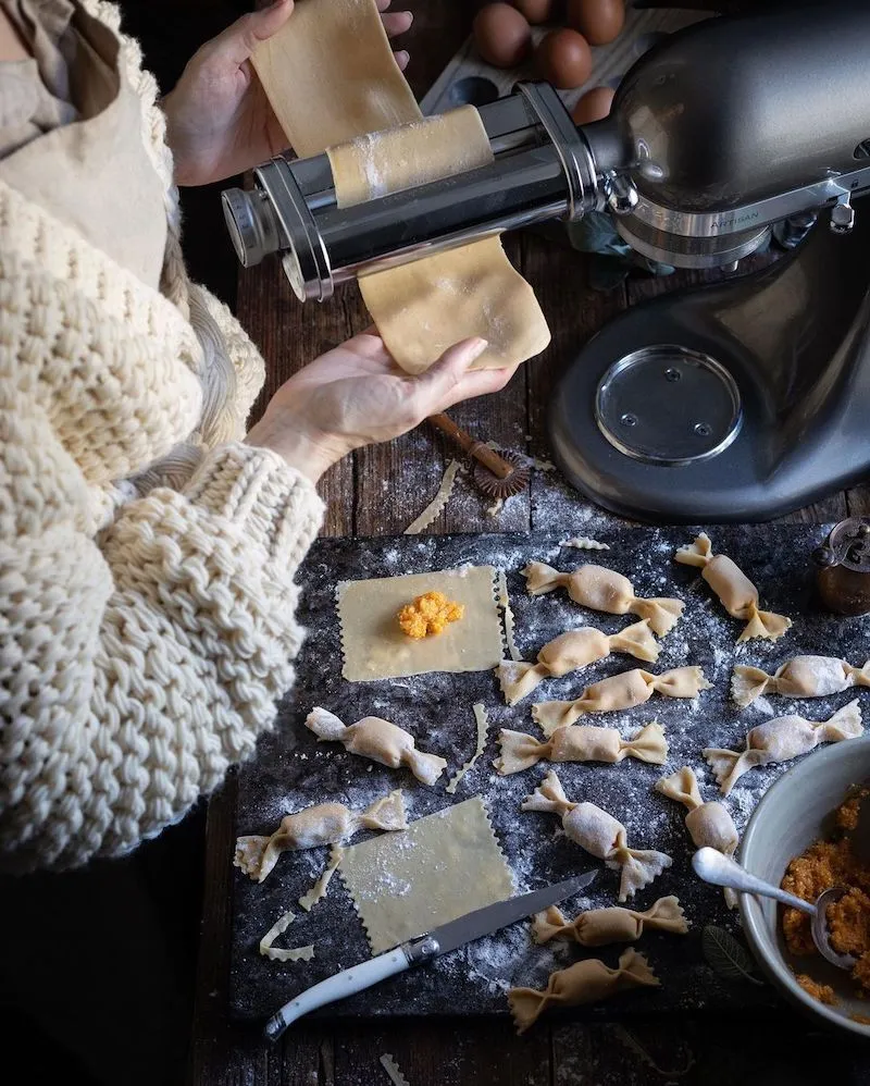 Photography of someone making pasta with some candy shaped raviolis on the table