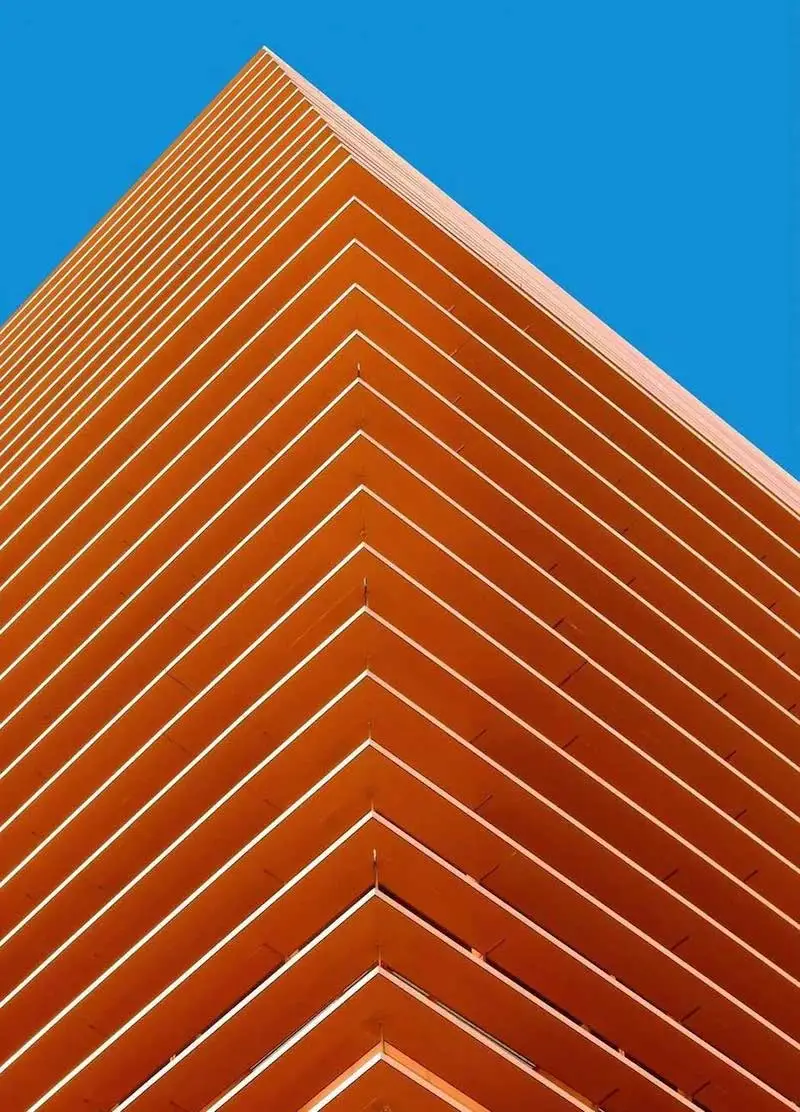 Photography of an orange building with a blue sky behind, taken by Ash Camas, contemporary architecture photographer