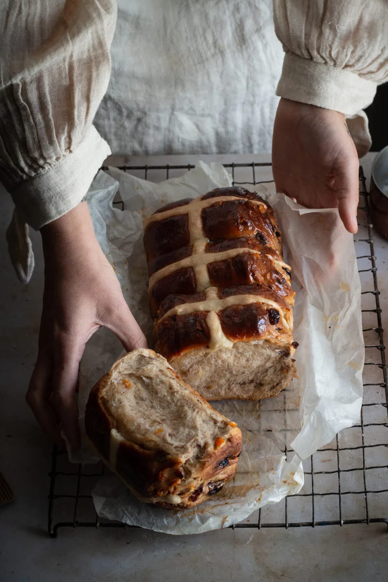 Photography of someone taking a piece from a loaf of bread, taken by Aimee Twigger, food photographer